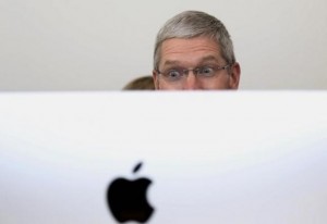 Apple CEO Tim Cook looks at a new IMac after a presentation at Apple headquarters in Cupertino, California October 16, 2014.  REUTERS/Robert Galbraith